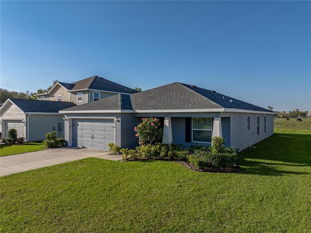 view of front of property with concrete driveway, a front yard, roof with shingles, stucco siding, and an attached garage