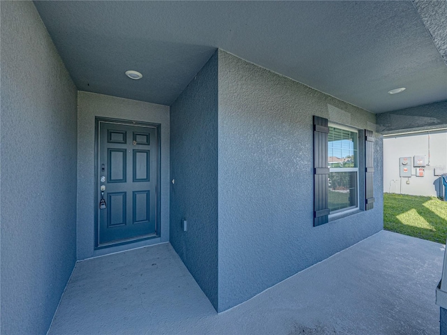 view of exterior entry with stucco siding