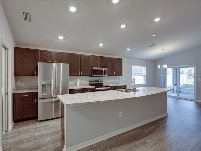 kitchen featuring visible vents, light wood finished floors, a sink, stainless steel appliances, and light countertops