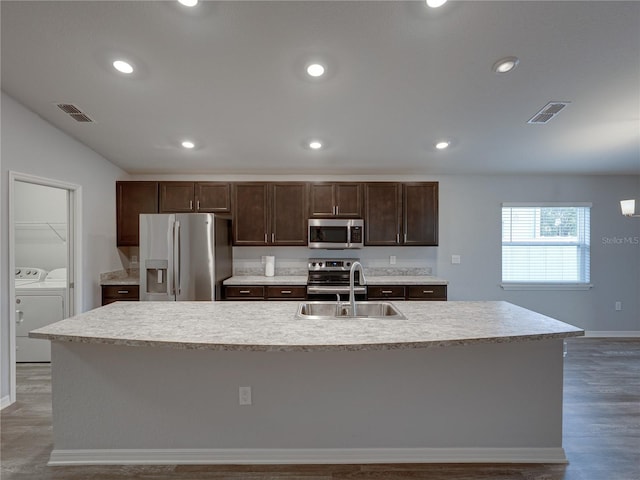 kitchen featuring visible vents, a sink, dark brown cabinets, appliances with stainless steel finishes, and washer and clothes dryer