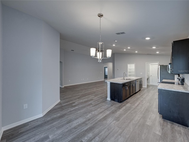 kitchen featuring visible vents, light wood-type flooring, light countertops, and a sink