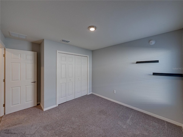 unfurnished bedroom with visible vents, baseboards, carpet, and a closet