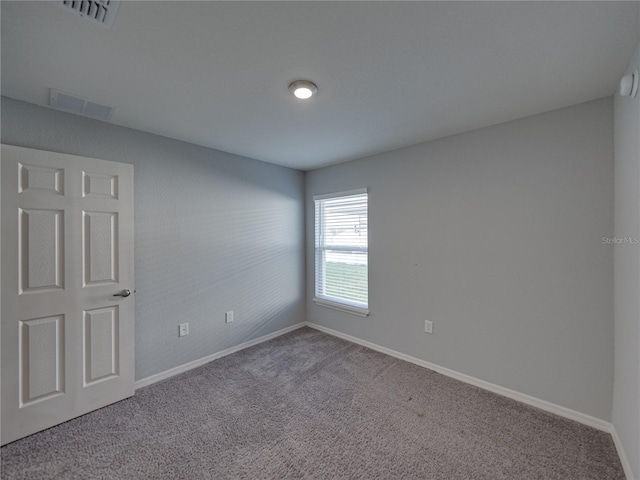 carpeted empty room featuring visible vents and baseboards