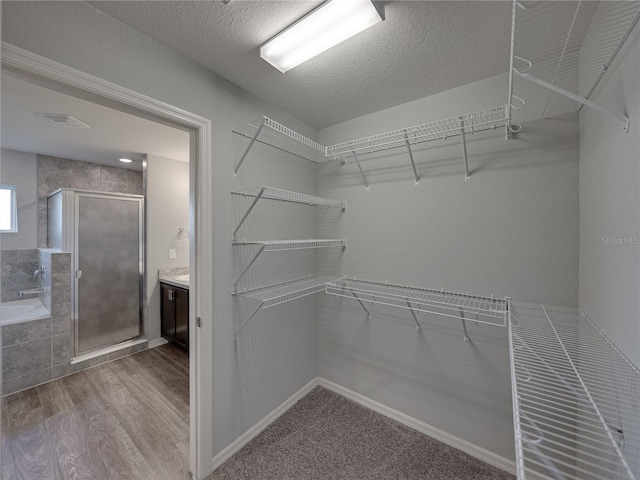 walk in closet featuring visible vents and wood finished floors