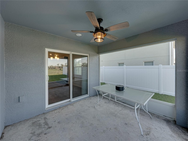 view of patio with ceiling fan and fence