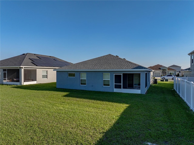 back of house featuring a yard, fence, a sunroom, and stucco siding