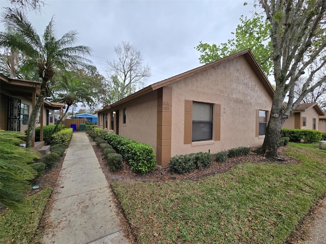 view of home's exterior with a lawn and stucco siding