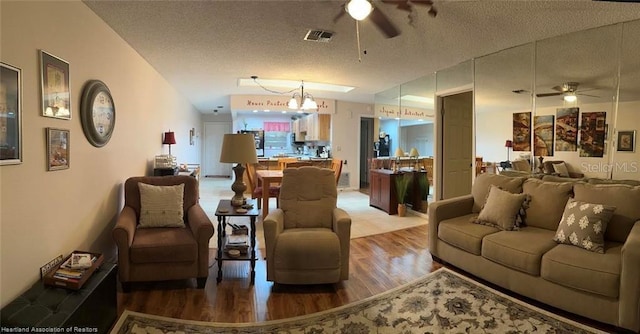 living area featuring a textured ceiling, visible vents, wood finished floors, and a ceiling fan