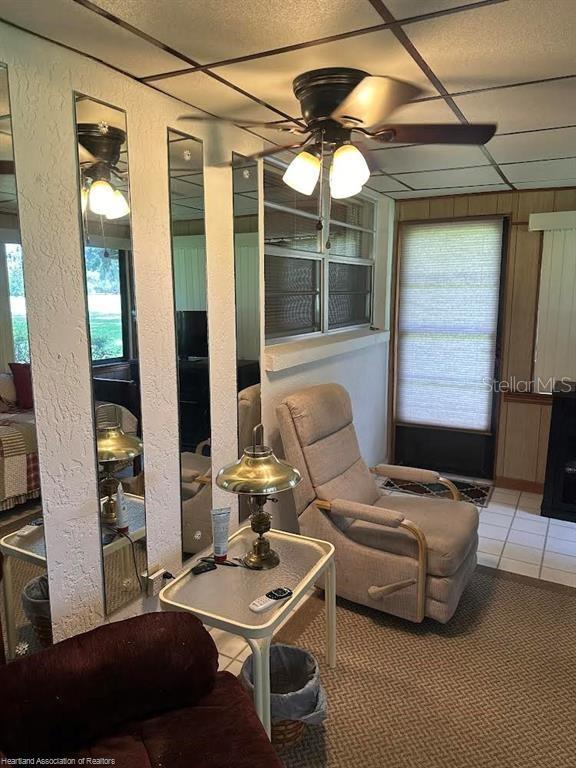 interior space featuring ceiling fan and a drop ceiling