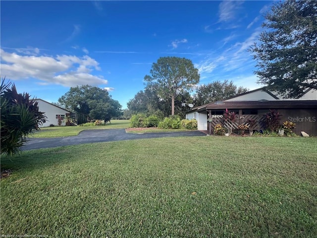 view of yard featuring a garage and driveway