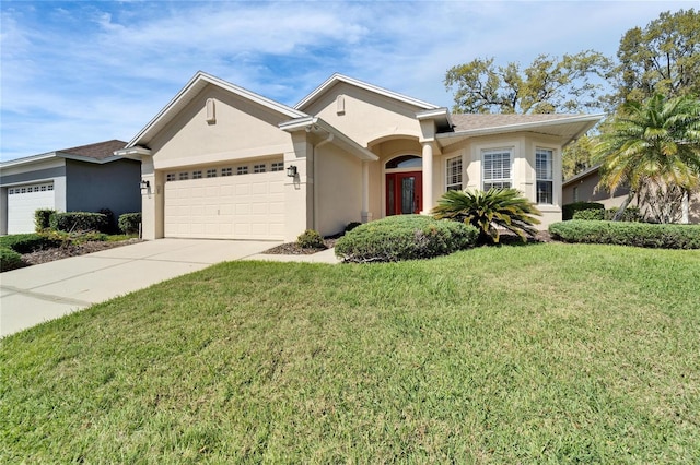 ranch-style house with a garage, a front yard, concrete driveway, and stucco siding