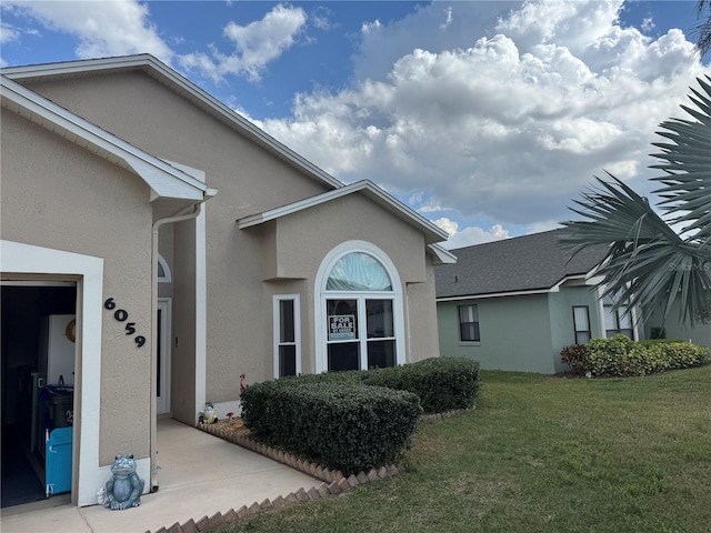 view of side of property featuring a yard and stucco siding