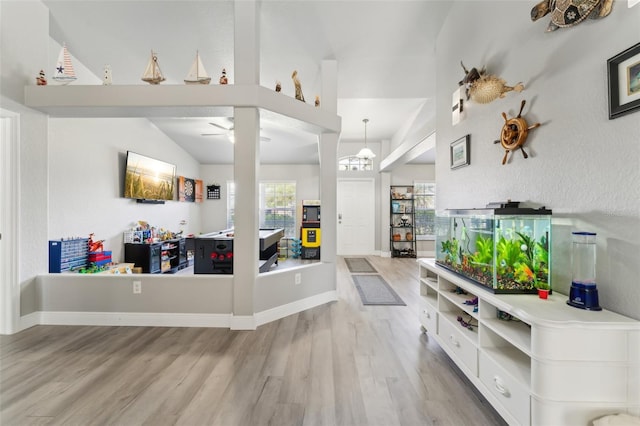 living room with lofted ceiling, wood finished floors, and baseboards