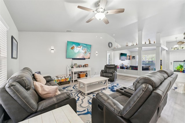 living area with light wood finished floors, visible vents, vaulted ceiling, ceiling fan, and baseboards