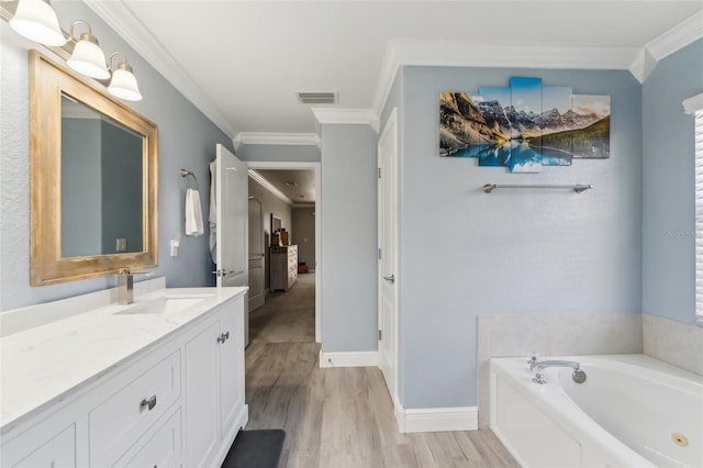 full bath featuring wood finished floors, vanity, visible vents, ornamental molding, and a bath