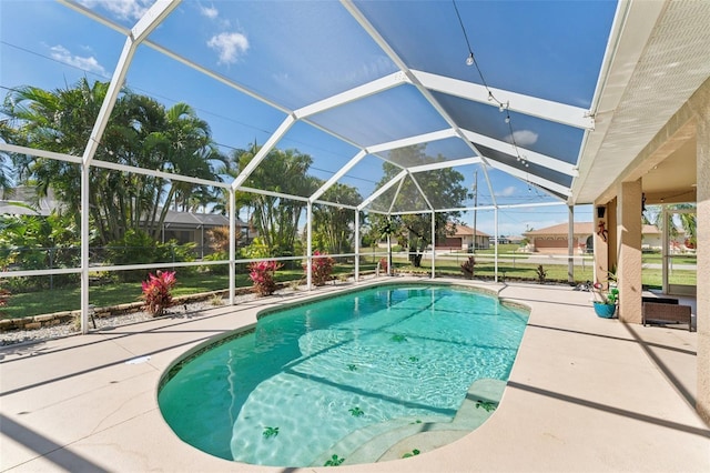 pool featuring glass enclosure and a patio