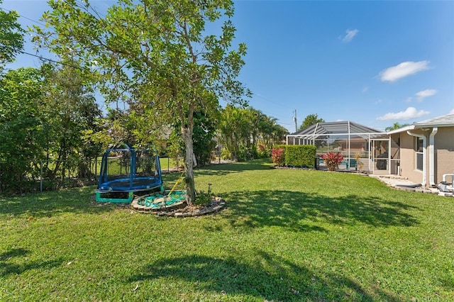 view of yard featuring a trampoline, glass enclosure, a fenced backyard, and a swimming pool