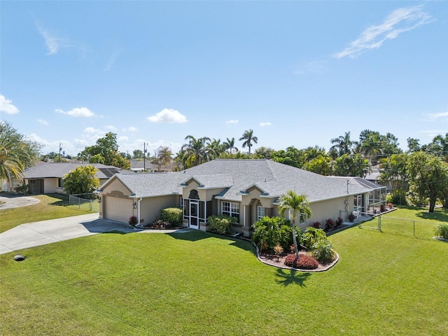 ranch-style home with a garage, fence, driveway, stucco siding, and a front lawn