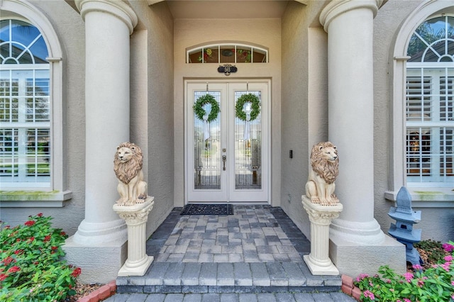 property entrance featuring french doors and stucco siding