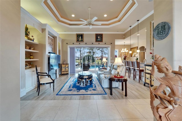 living area featuring light tile patterned flooring, recessed lighting, ceiling fan with notable chandelier, ornamental molding, and a tray ceiling