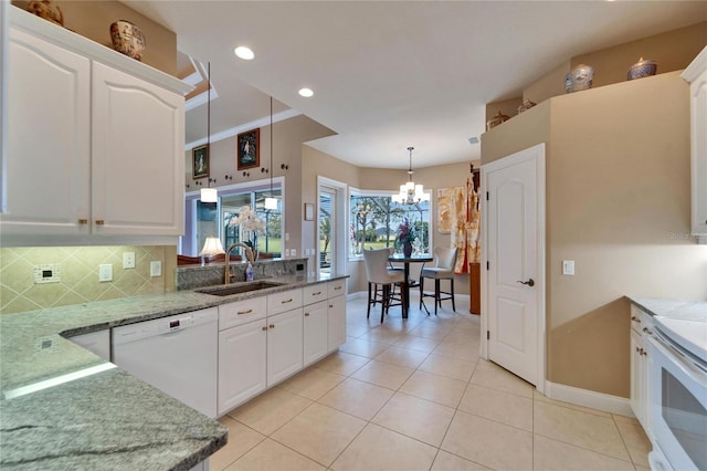 kitchen featuring white appliances, backsplash, a sink, and white cabinetry