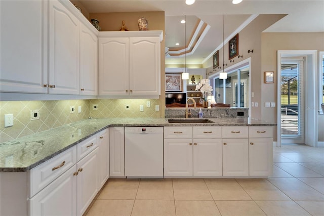 kitchen featuring crown molding, a raised ceiling, white cabinets, white dishwasher, and a sink