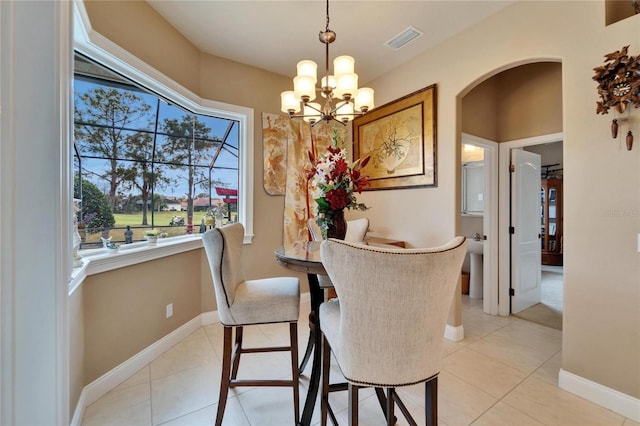 dining area with arched walkways, light tile patterned floors, visible vents, and baseboards