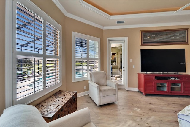 sitting room with ornamental molding, wood finished floors, visible vents, and baseboards