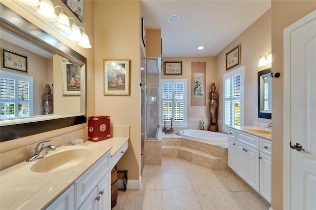 bathroom with a garden tub, a shower stall, a sink, and tile patterned floors