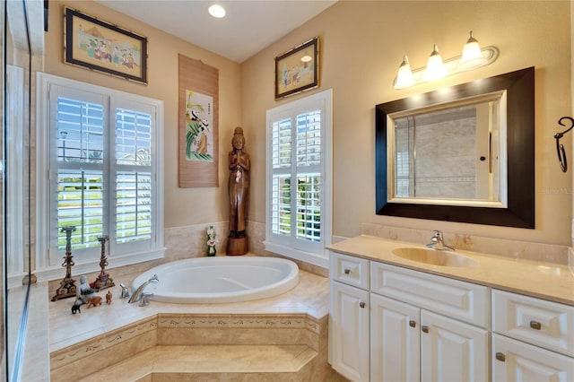 bathroom with a garden tub and vanity