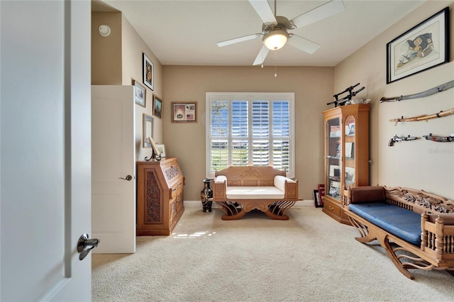 living area featuring carpet floors and ceiling fan