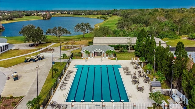 community pool featuring a water view and fence