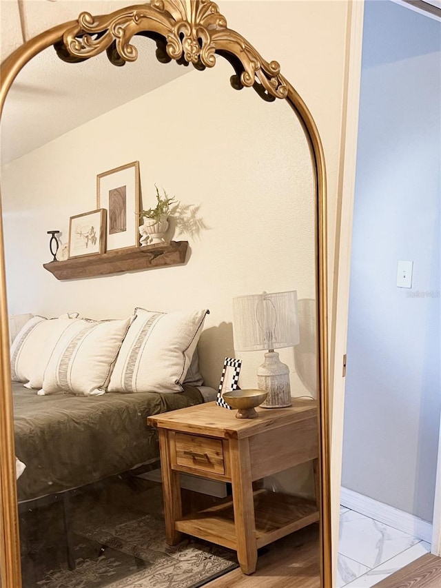 interior space with vaulted ceiling, marble finish floor, and baseboards