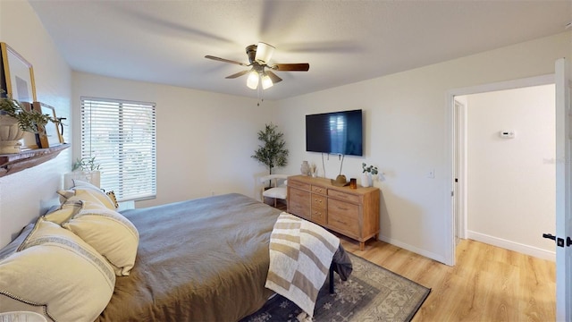 bedroom with baseboards, ceiling fan, and light wood-style floors