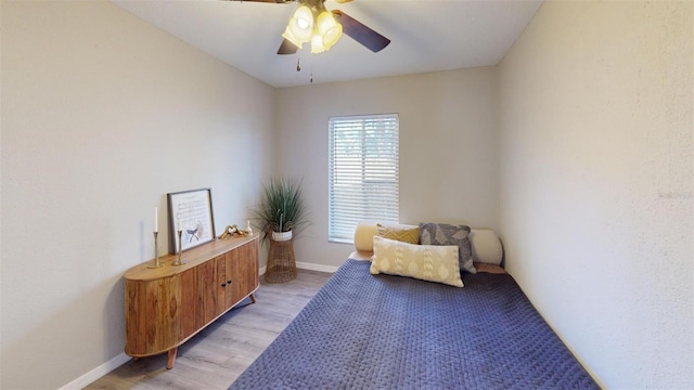 living area with light wood-style flooring, baseboards, and ceiling fan