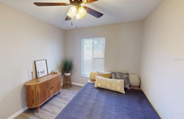 sitting room featuring baseboards, ceiling fan, and light wood-style floors