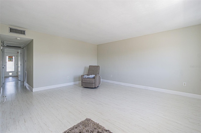 unfurnished room featuring visible vents, baseboards, and wood finished floors