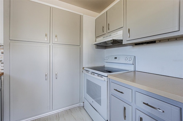 kitchen with light countertops, gray cabinets, white electric range oven, and under cabinet range hood