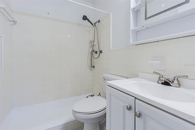 full bath with toilet, tile walls, tiled shower, and vanity