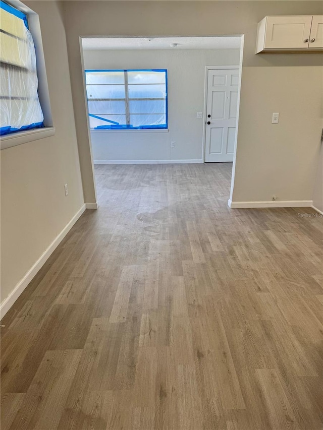 unfurnished living room featuring light wood-style flooring and baseboards