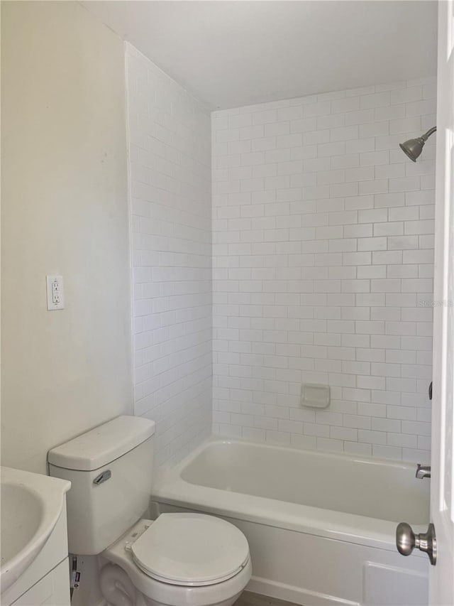 bathroom featuring toilet, washtub / shower combination, and vanity