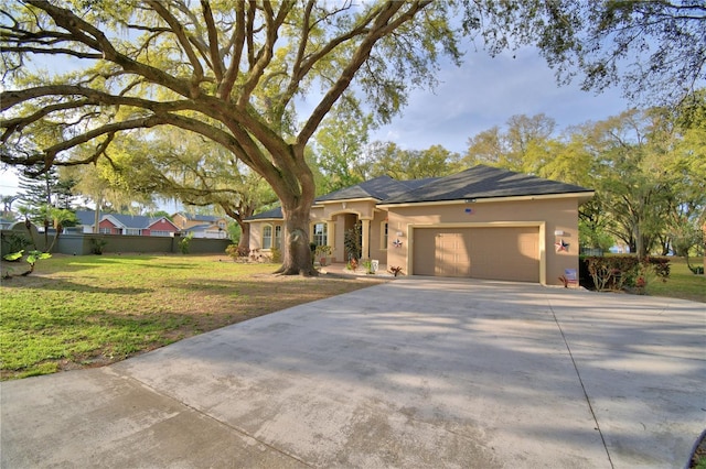 ranch-style house with a front lawn, driveway, an attached garage, and stucco siding