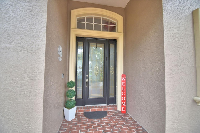 doorway to property featuring stucco siding