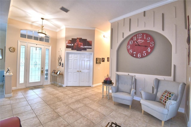 foyer entrance featuring visible vents, crown molding, baseboards, and light tile patterned flooring