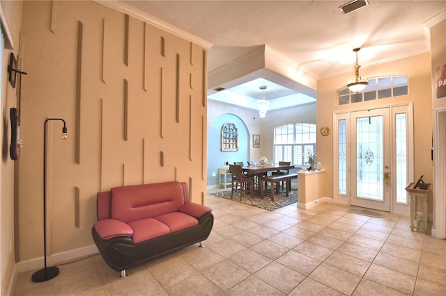 entrance foyer with baseboards, light tile patterned flooring, visible vents, and crown molding