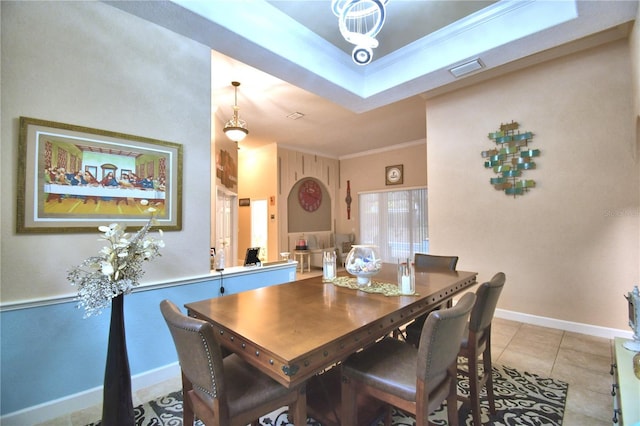 dining room with baseboards, visible vents, a raised ceiling, ornamental molding, and light tile patterned flooring