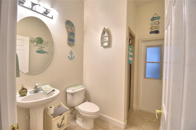 full bath with toilet, a sink, baseboards, tile patterned floors, and walk in shower