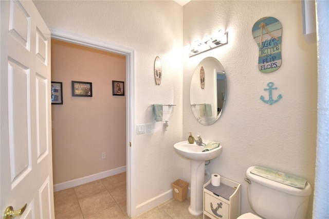 bathroom featuring toilet, tile patterned flooring, and baseboards