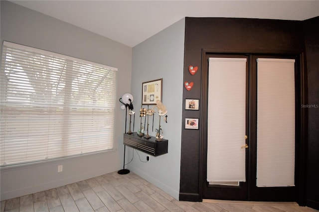 entrance foyer with french doors, wood finished floors, and baseboards