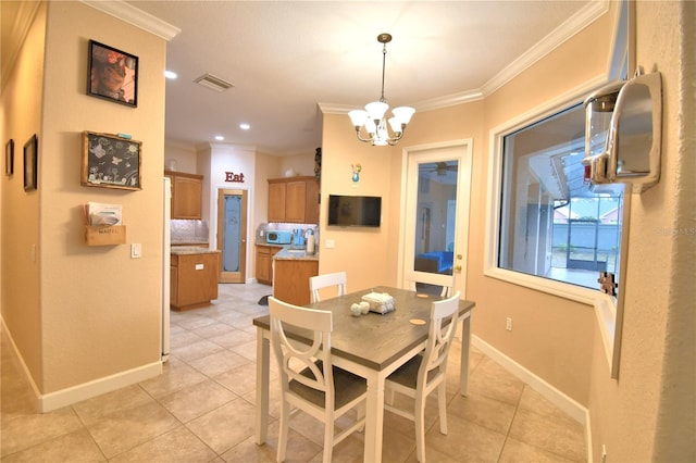 dining space with baseboards, visible vents, crown molding, and light tile patterned flooring